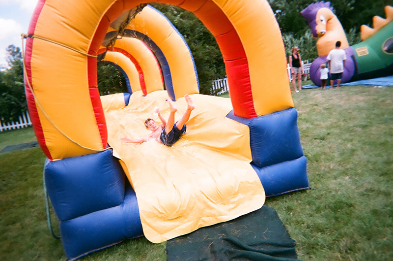 Boy sliding down the wet water slide